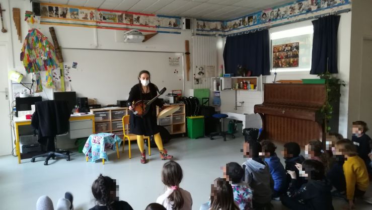 La conteuse Rosaline Deslauriers avec sa mandoline devant les élèves