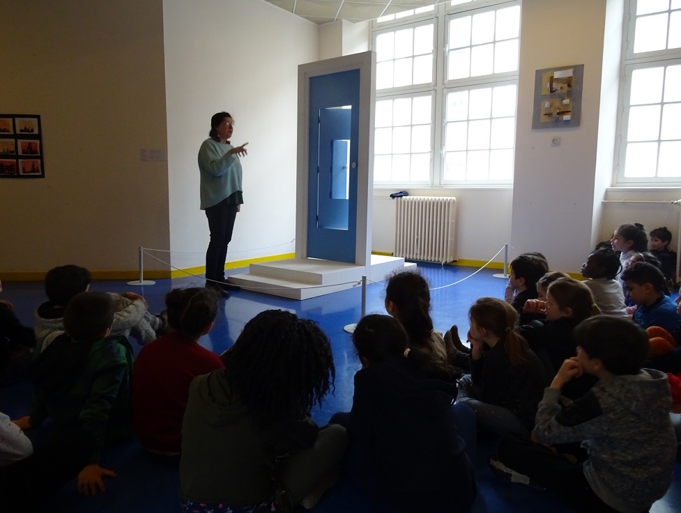 Devant son oeuvre, l'artiste Florence Doléac explique son travail plastique, dans une salle de l'école élémentaire Tlemcen.