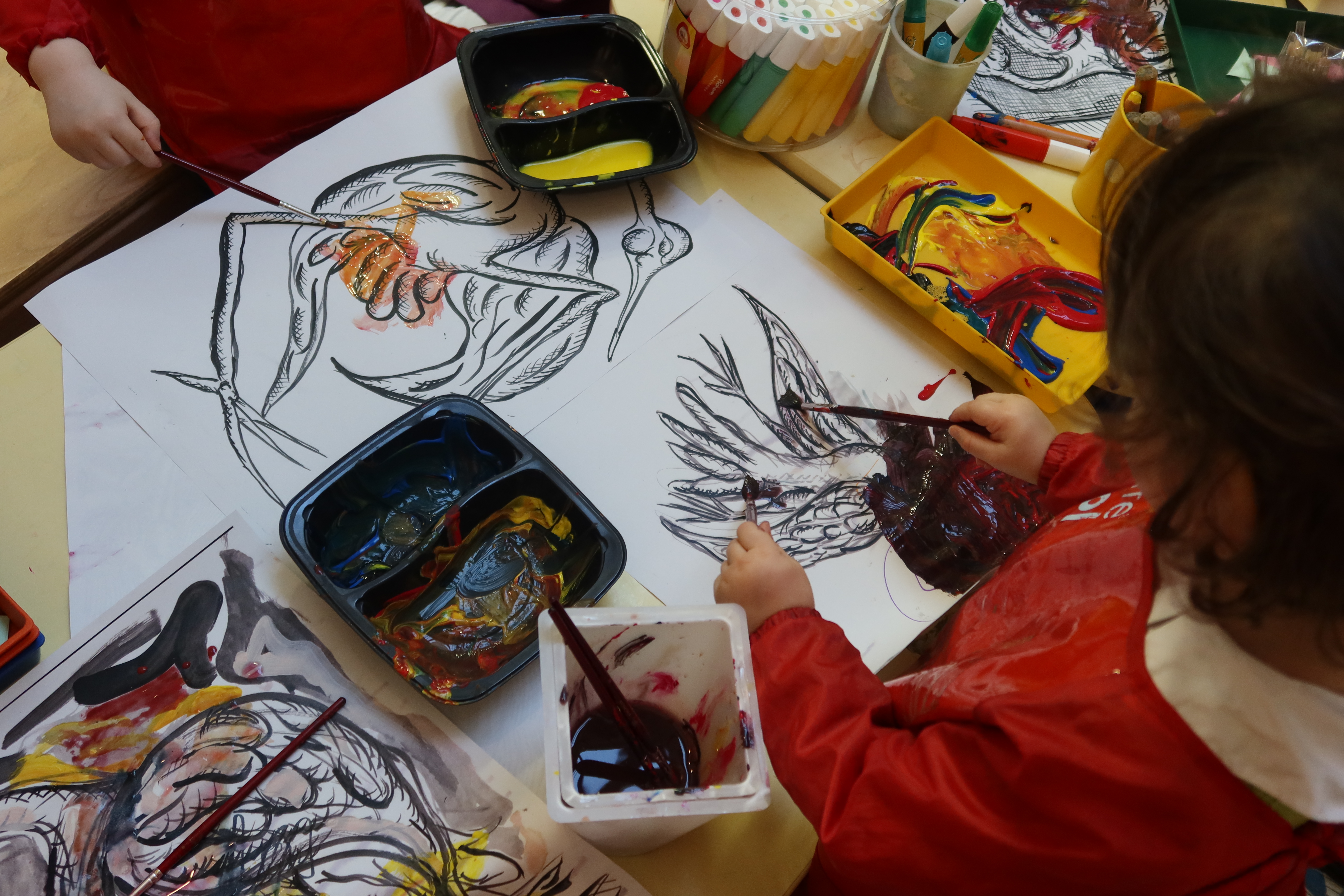 Les enfants colorient leurs oiseaux en jaune et en rouge
