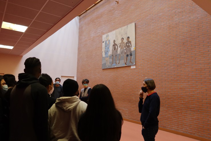 Les élèves observent l'oeuvre accrochée au collège en présence de leur professeur et de l’artiste