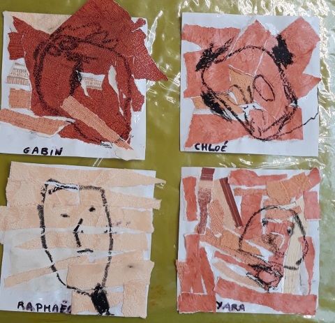 Des travaux d'élèves autour l’œuvre Red Head de James Brown représentant des portraits sont disposés sur une table d'une salle de l'école maternelle Maurice Ripoche (14e).