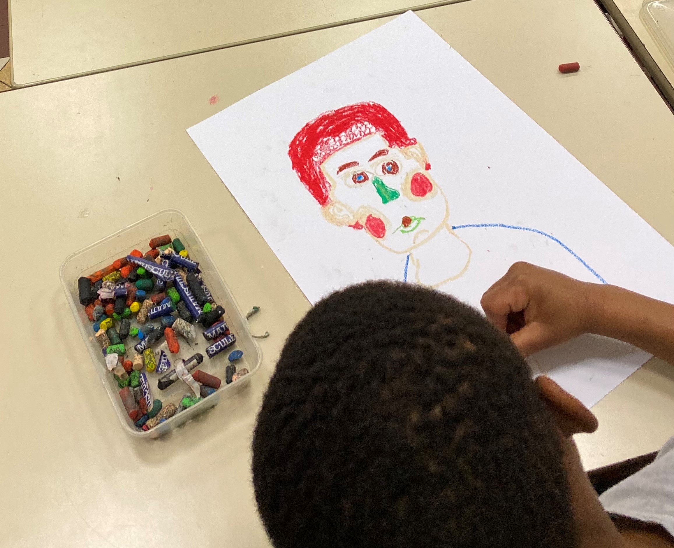 Enfant dessinant son portrait ou celui de son camarade de classe