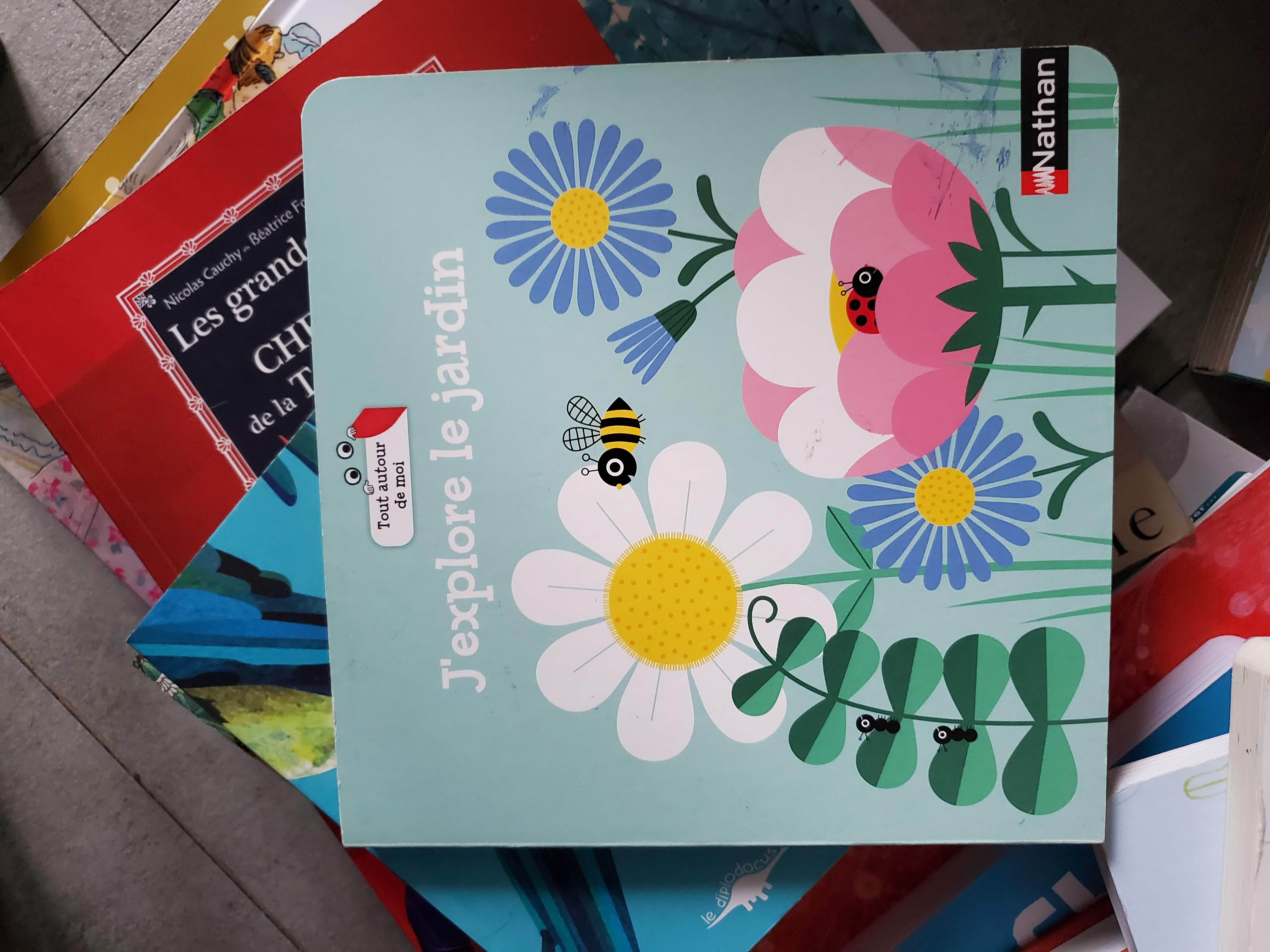 Zoom sur la couverture du livre " Printemps " posé sur une pile de livres