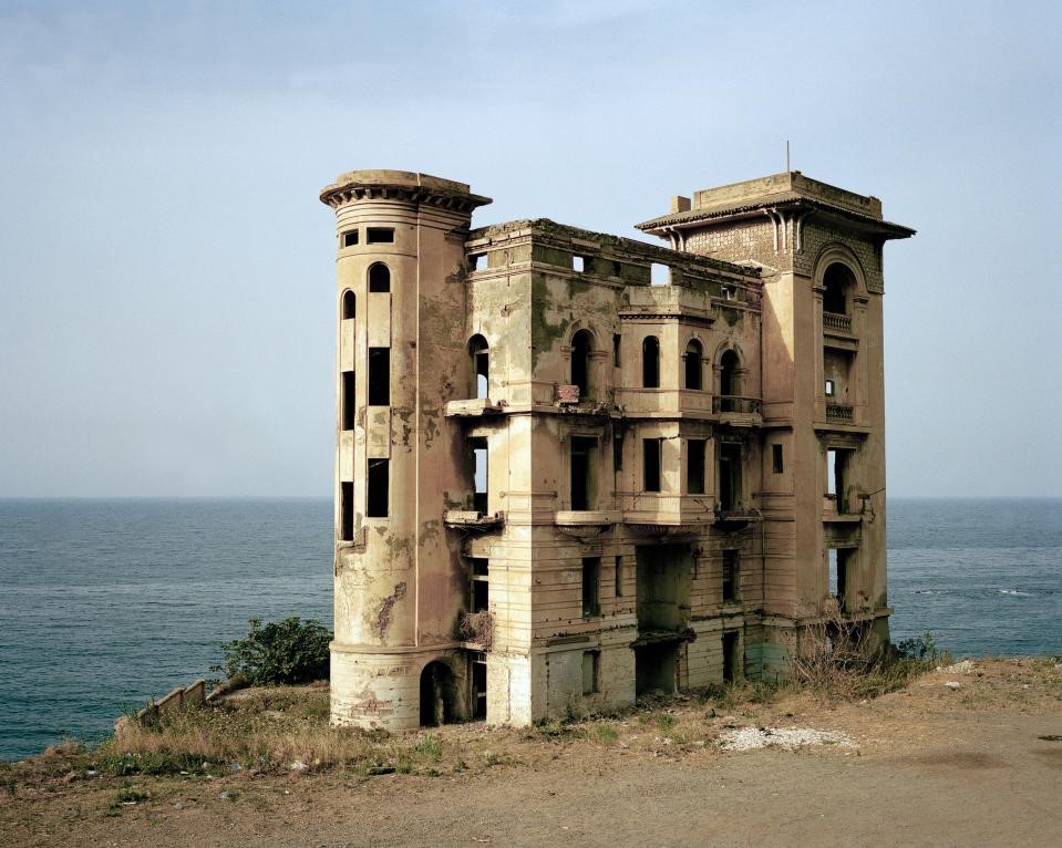 Photographie de l'artiste Zineb Sedira représentant une maison abandonnée en bord de mer.