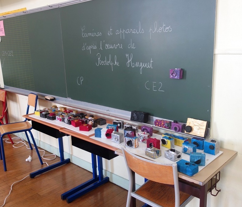 Exposition sur une table des caméras de surveillance réalisées avec des matériaux de récupération, par les CE2 de l'école élémentaire Arago (13e), en avril 2019.