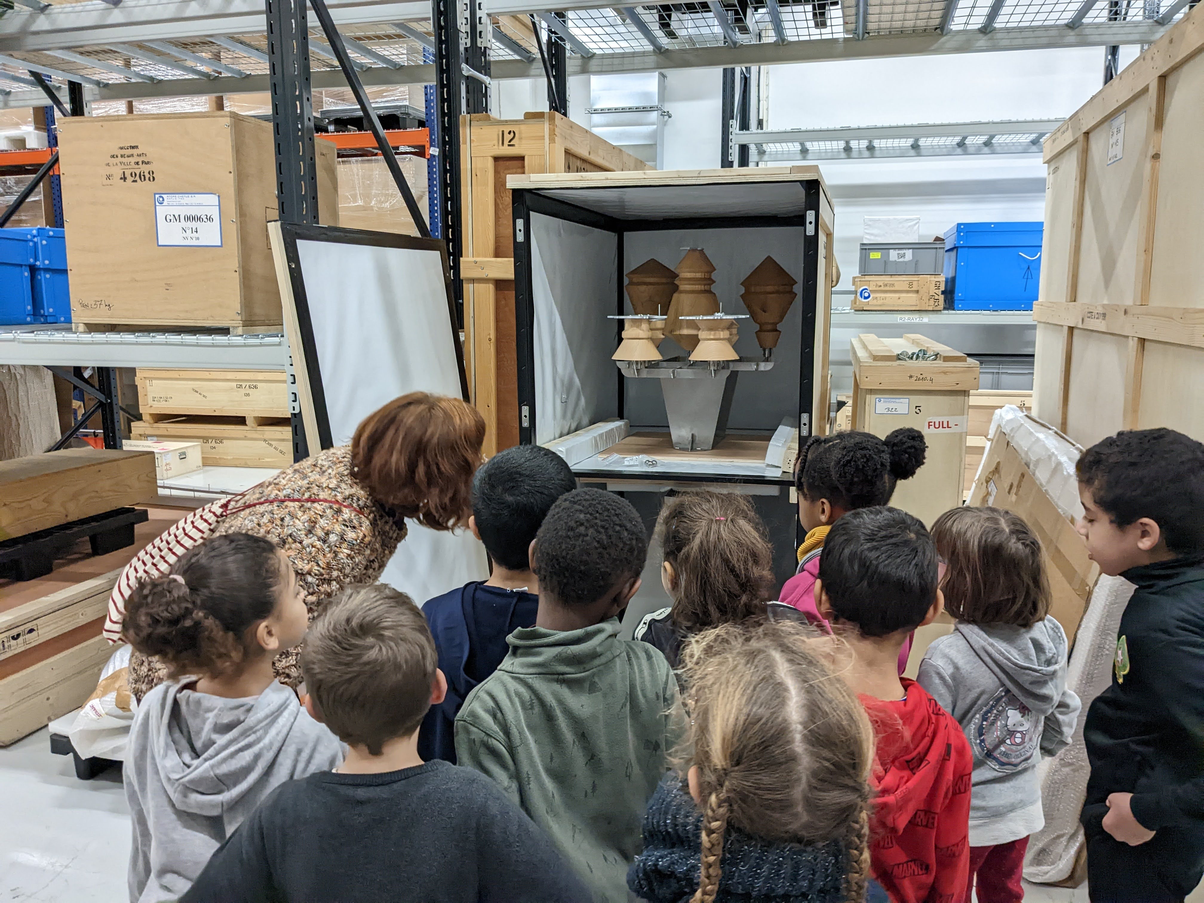 Les CE1 de l'école élémentaire de Télégraphe découvrent les réserves du Fonds. Ici, une caisse de conservation ouverte dévoile des détails de l'œuvre de Florian Sumi, intitulée [Clockworks #2] de 2014.