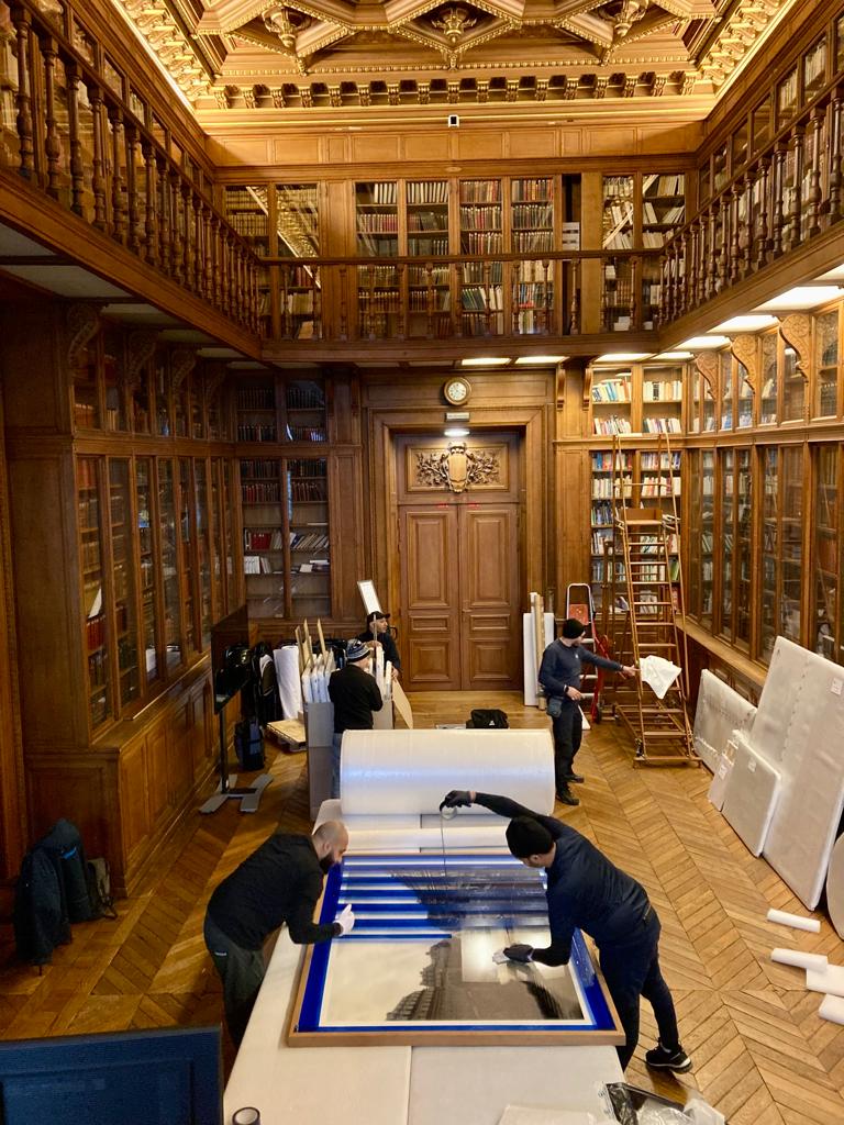 Dans la bibliothèque du Conseil de Paris, à l'Hôtel de Ville, les équipes du Fonds et de la société ESI organisent le conditionnement des œuvres pour leur retour en réserves, dans le 18e.