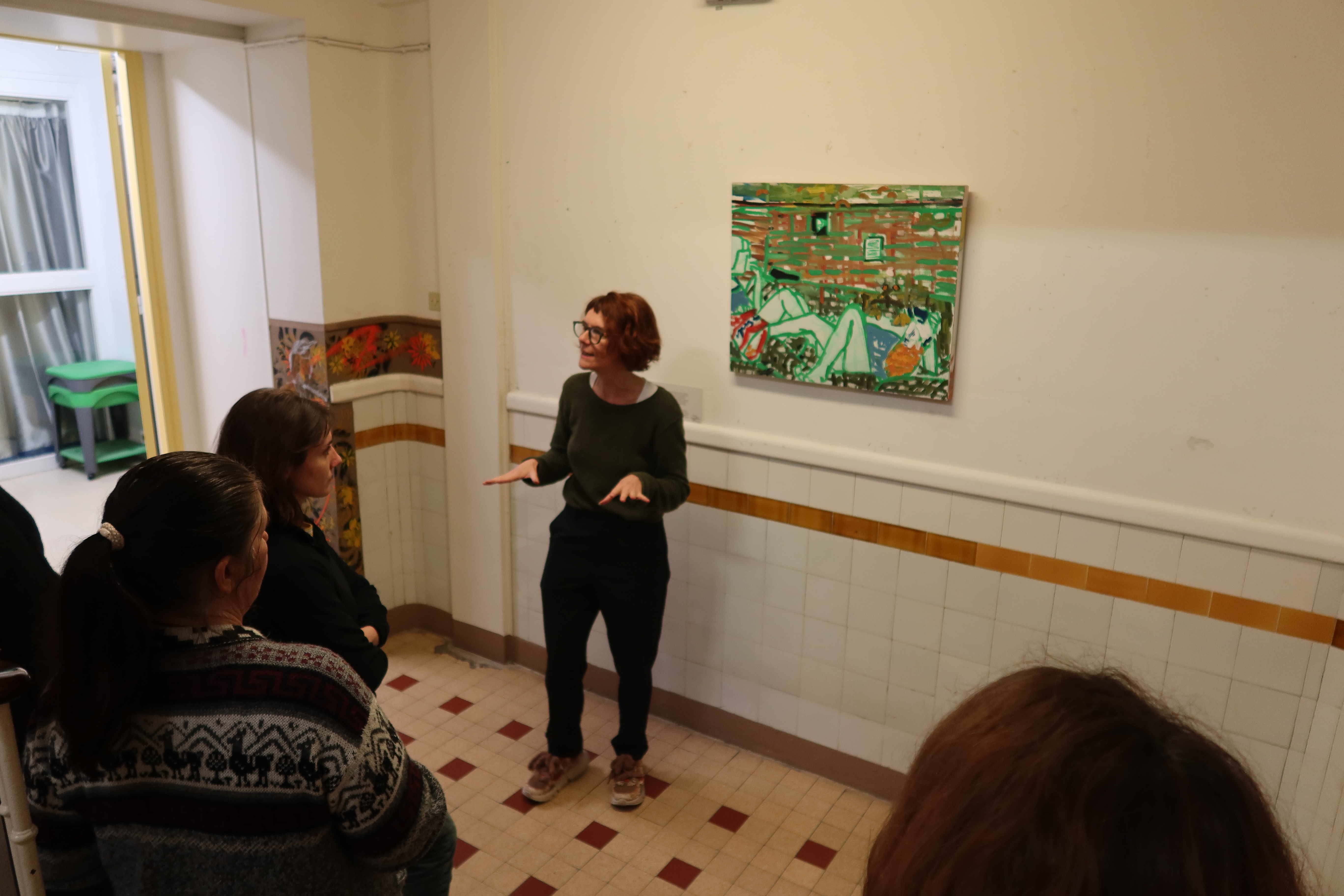 L'équipe pédagogique de l'école maternelle Delambre (14e) échange avec Nathalie Rataud sur le tableau [Chipseaters] de l'artiste Regine Kolle