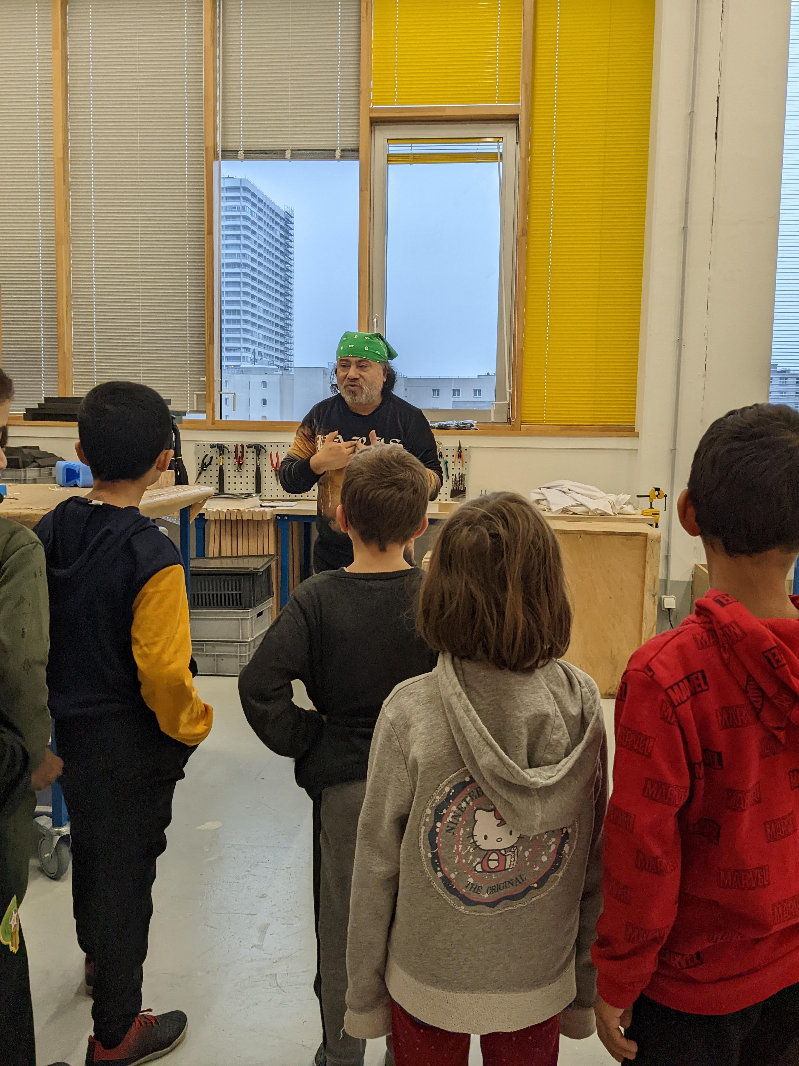 Les scolaires de la classe Ce1 de l'école du Télégraphe (20e) rencontre dans l'atelier de la régie un installateur monteur qui leur décrit son travail et les matériaux utilisés pour conserver les oeuvres.
