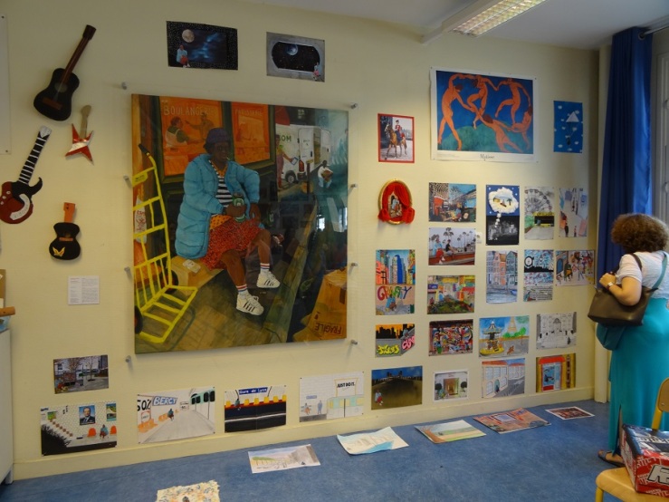 Photographie d'un mur de classe du collègue Paul Verlaine (12e) sur lequel sont exposées l'œuvre de Julien Beneyton [La Discrète] et les réalisations des scolaires, sur le même thème de l'oeuvre.