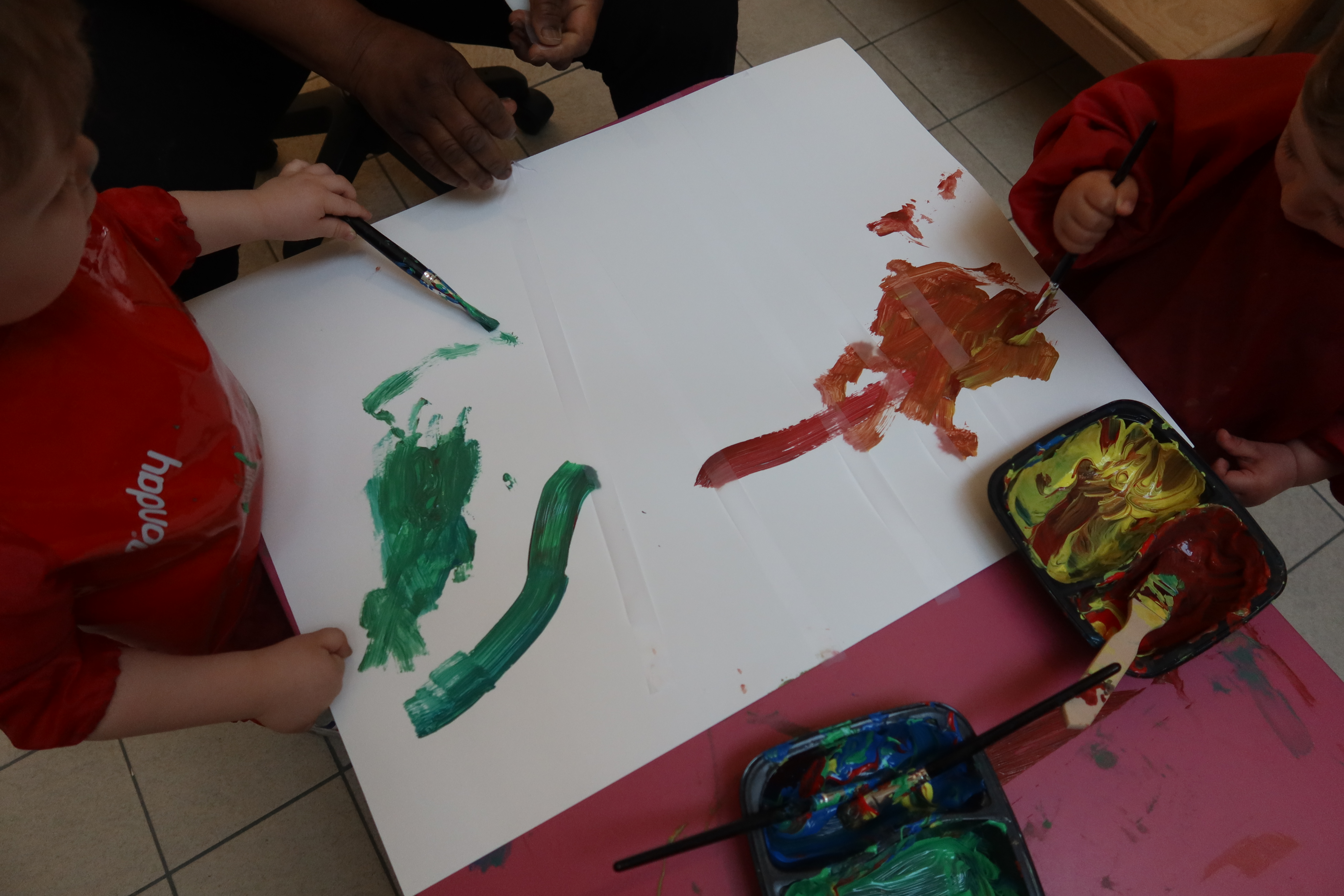 Des bébés de la crèche Dunkerque (9e) s'essayent à la peinture accompagné.es par l'équipe de professionnelles