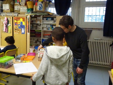 Dans la classe de l'école élémentaire Saint-Maur (20e), l'artiste Armand Jalut conseille un enfant pendant un atelier plastique.